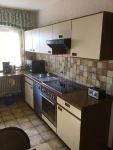 a kitchen with a sink and a stove top oven at Haus Muckenbruchblick -Ferienwohnung- in Erwitte
