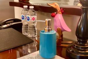 un dispensador de jabón azul sobre una mesa con botellas de agua en St-Sauveur Lovely Studio en Piedmont