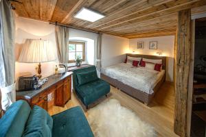 ein Schlafzimmer mit einem Bett, einem Schreibtisch und einem Sofa in der Unterkunft Adelwöhrer Bauernhaus in Falting