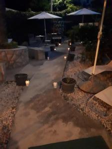 a patio with candles and umbrellas at night at Apartments Petra 23 in Mali Lošinj