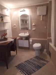 ein Badezimmer mit einem Waschbecken, einem WC und einem Spiegel in der Unterkunft Apartments Petra 23 in Mali Lošinj