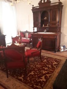 a living room with red chairs and a table at Apartments Petra 23 in Mali Lošinj