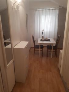 Zimmer mit einem Schreibtisch, einem Tisch und Stühlen in der Unterkunft Apartments Petra 23 in Mali Lošinj