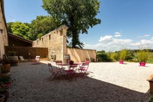 a patio with a table and chairs in a yard at Mas du Cres Gîte in Galargues
