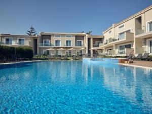 a large swimming pool in front of some apartment buildings at Zoi Apartments in Tsilivi