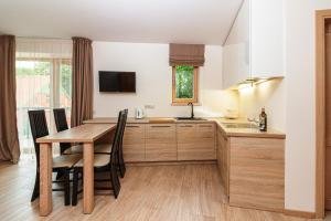 a kitchen with a wooden table and a dining room at Sveciu Namas 9 in Palanga