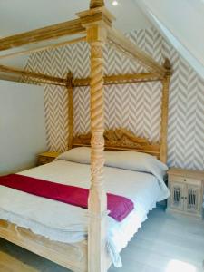 a bedroom with a wooden four poster bed at Demeure de charme haut de gamme - Piscine chauffée in Lissewege
