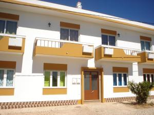 ein Gebäude mit Balkon und Tür in der Unterkunft Casa Branca in Armação de Pêra