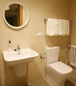 y baño con lavabo, aseo y espejo. en Casa Matías en Sarria