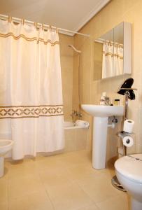 ein Bad mit einem Waschbecken, einem WC und einer Dusche in der Unterkunft Apartamento Golf Rioja Alta in Cirueña