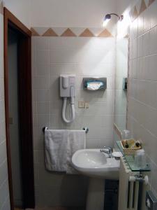 baño con lavabo y teléfono en la pared en Casa Gori en Certaldo