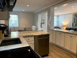 a kitchen with white cabinets and a counter top at Tybeeland Steps to the Beach with Oceanviews, Beachside of Butler Ave in Tybee Island