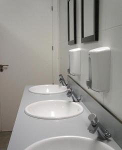 a bathroom with two sinks and two paper towels at Albergue Santiago Apostol in Logroño