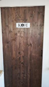 Una puerta de madera con la palabra kde en ella en Bungalow(hälfte) Vorderdeck, Ahlbeck (Usedom), en Ahlbeck