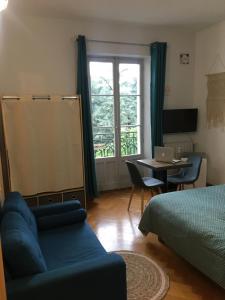 - une chambre avec un lit et une table avec un ordinateur portable dans l'établissement Les petits boudoirs beau site, à Aix-les-Bains