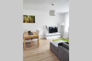 ein Wohnzimmer mit einem Sofa und einem Tisch in der Unterkunft Ferienwohnung am Teutoburger Wald 1 in Oerlinghausen