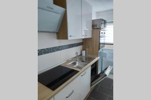 a kitchen with white cabinets and a sink at Ferienwohnung am Teutoburger Wald 1 in Oerlinghausen