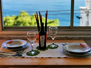 un tavolo con una bottiglia di vino e due bicchieri di Villa Mirella Sea View Apartments a Positano