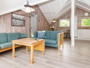 - un salon avec un canapé bleu et une table dans l'établissement 8 person holiday home in Toftlund, à Toftlund