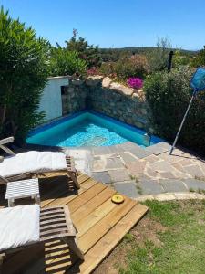 una piscina con terrazza in legno e una piscina di Casa Vacanza Porto Luna 68 a Villasimius
