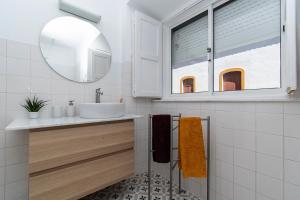 een witte badkamer met een wastafel en een spiegel bij Guadiana River Apartment in Vila Real de Santo António +41 foto's