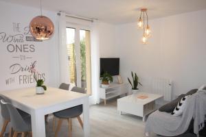 a white living room with a table and a couch at Apartamentos La Herradura Terraza in Haro