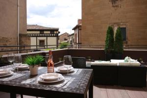 una mesa con platos y copas de vino en el balcón en Apartamentos La Herradura Terraza, en Haro