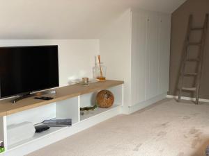a living room with a flat screen tv on a shelf at L'Auf der Tomm in Martelange