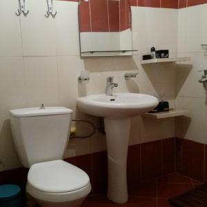La salle de bains est pourvue de toilettes blanches et d'un lavabo. dans l'établissement Home Away From Home, à Saranda