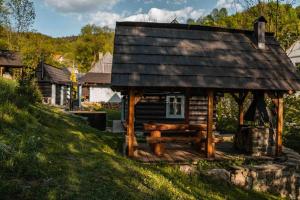 a log cabin with a bench in the grass at Zbojnícke Chalúpky in Čavoj +38 photos