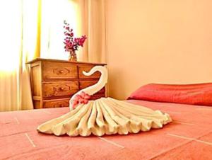 a swan decoration on a bed in a bedroom at Hotel Cordelia's in Puerto &Aacute;ngel