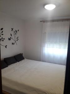 uma cama branca num quarto com uma janela em Apartment Noletov vidikovac em Vrdnik
