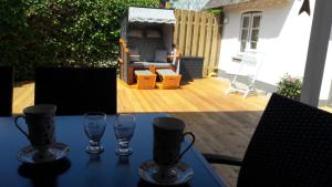 a blue table with two wine glasses on a patio at Dat Schmucke Huus in Schwabstedt