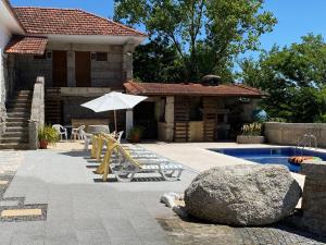 a house with a swimming pool and a patio with an umbrella at Havan House in Amarante