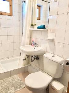 a white bathroom with a toilet and a sink at Pearl Home Siofok in Siófok +30 photos