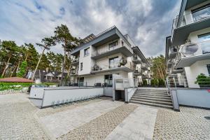 a large white building with stairs in front of it at Baltic 4YOU in Pobierowo
