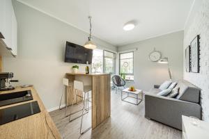 a living room with a couch and a kitchen at Baltic 4YOU in Pobierowo