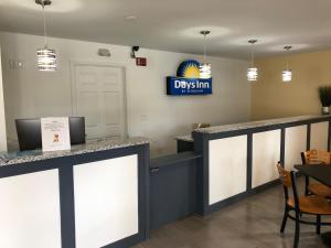 a restaurant with a desk with a sign on the wall at Days Inn by Wyndham Cape Carteret in Cape Carteret