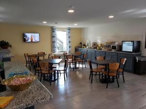 a restaurant with tables and chairs and a kitchen at Days Inn by Wyndham Cape Carteret in Cape Carteret