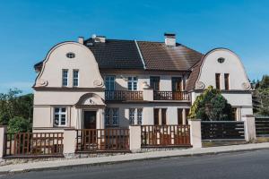 ein großes weißes Haus mit einem Holzzaun in der Unterkunft Penzion U Pivovaru in Děčín