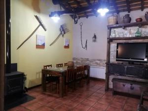 Un comedor con una mesa y un televisor. en EL MOLINO, en Sequeros 8 fotos más