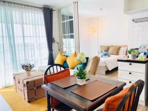 uma sala de estar com uma mesa e um sofá em Summer Condo Hua Hin Room710 em Hua Hin