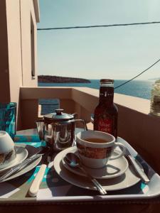 una mesa con una taza de café y una botella de sirope en Pension Mylos, en Agios Nikolaos