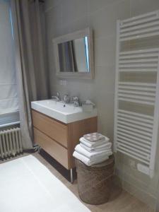 La salle de bains est pourvue d'un lavabo et d'un miroir. dans l'établissement Chambres d'Hôtes La Maison, à Rouen