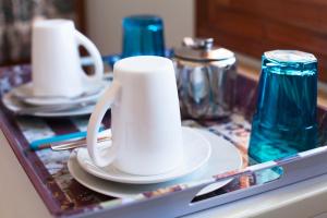 a white coffee cup sitting on a table with plates at Pension Mylos in Agios Nikolaos