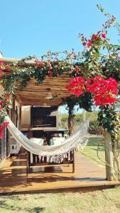 a hammock on a wooden deck with red flowers at Tacheles in José Ignacio