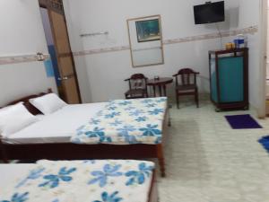- une chambre avec 2 lits, une table et des chaises dans l'établissement Thanh Binh Hotel, à Buôn Ma Thuột