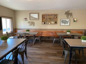 a restaurant with tables and chairs in a room at Rockerville Lodge & Cabins in Keystone
