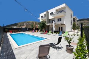 Villa con piscina frente a una casa en Apartments Bulli en Trogir