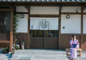 a woman in kimono standing outside of a building at Toraya in Gero